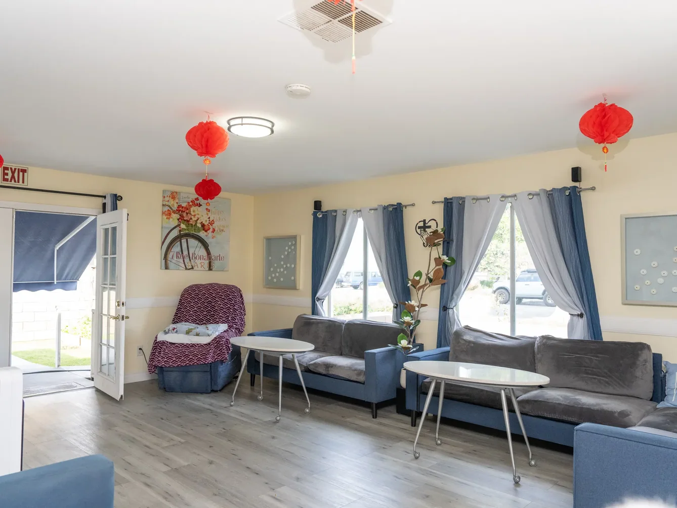 Welcoming communal living area with comfortable seating, natural light, and festive decorations in residential care facility