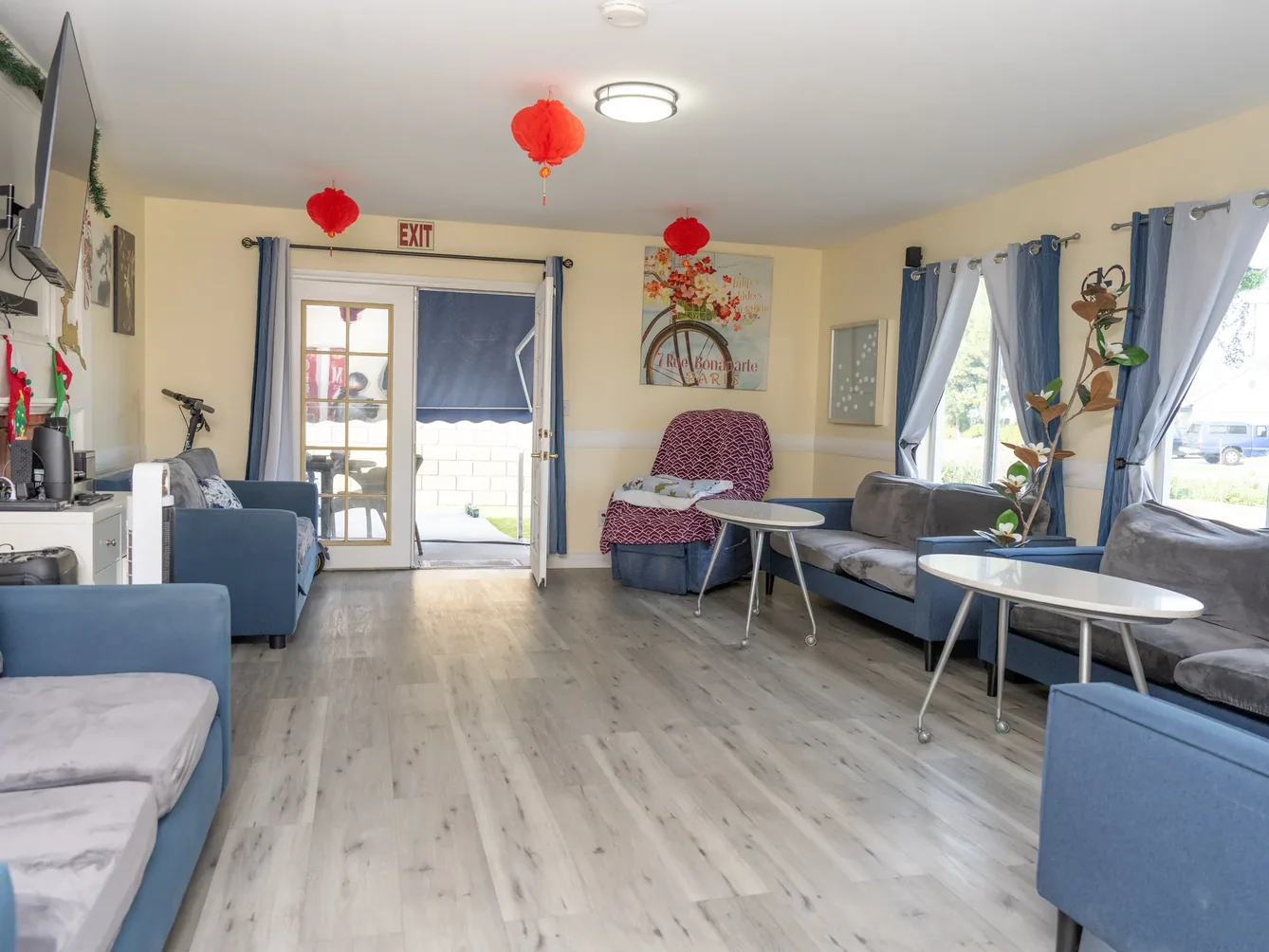Spacious common living area with multiple seating arrangements and natural light for resident socialization